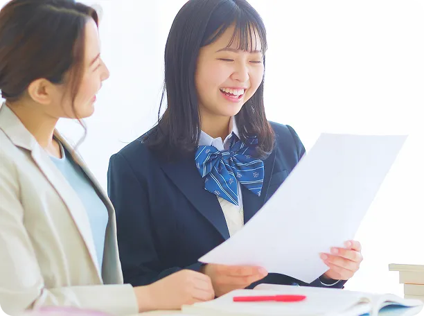 女性２人がプリントを見て笑顔になっている写真